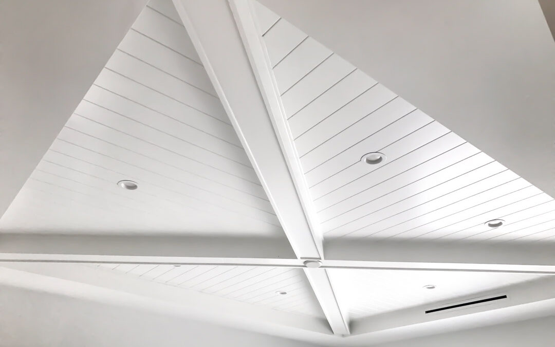 Vaulted white shiplap ceiling with recessed lighting, showcasing fine carpentry craftsmanship.